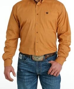 A man wearing jeans and a brown shirt.