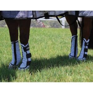 A pair of legs wearing boots in the grass.