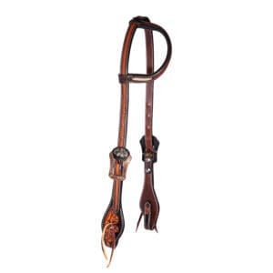 A brown and black leather horse harness hanging on the wall.